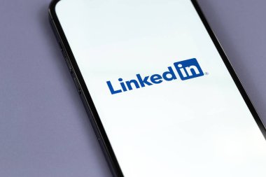 Bir ekrandaki akıllı telefon iPhone 'una bağlı logo mobil uygulaması. LinkedIn, iş bağlantılarını bulmak ve kurmak için kullanılan bir sosyal ağ. Batum, Gürcistan - 12 Ekim 2023