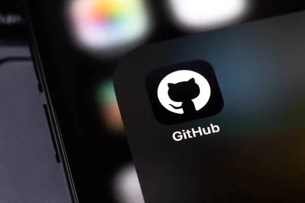 Stock image GitHub mobile icon app on a screen smartphone and notebook closeup. GitHub is the largest web service for hosting and developing IT projects. Batumi, Georgia - November 4, 2023