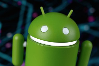 Google Android figürü yakın plan ve dijital arkaplan. Google Android akıllı telefonlar, tablet bilgisayarlar ve diğer cihazlar için bir işletim sistemidir. Batum, Gürcistan - 20 Aralık 2023