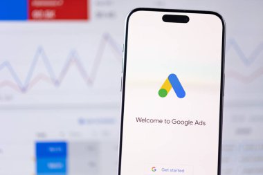 Google akıllı telefon iPhone ve Macbook arka planında logo uygulaması. Reklamlar, AdWords Google 'dan gelen bir arama reklamları servisidir. Batumi, Gürcistan - 26 Kasım 2023