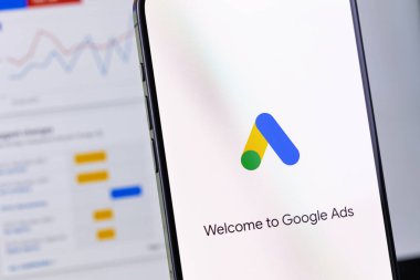 Google akıllı telefon iPhone ve Macbook 'un kapanış ekranındaki logo uygulaması. Reklamlar, temelde Google 'dan gelen bir arama reklamları servisidir. Batum, Gürcistan - 21 Kasım 2023
