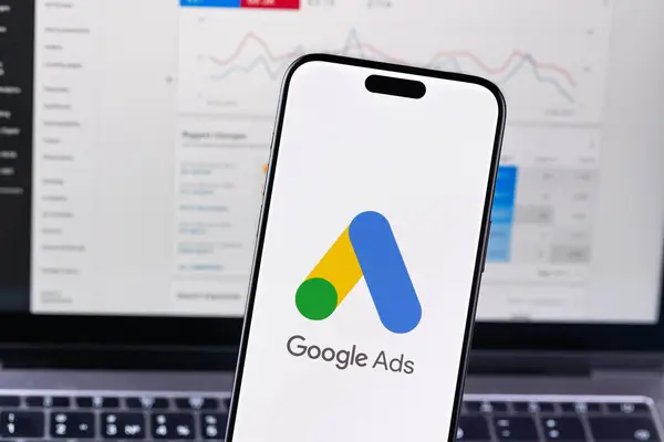 Google akıllı telefon iPhone ve Macbook arka planında logo uygulaması. Ads (Ad, AdWords), Google 'dan gelen bir arama reklamları servisidir. Batumi, Gürcistan - 26 Kasım 2023