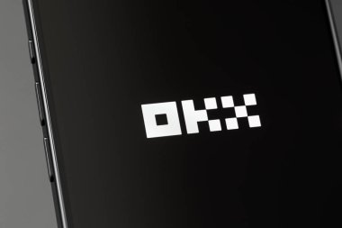 Ekran akıllı telefon iPhone 'unda OKX logo mobil uygulaması. OKX küresel bir kripto para birimi ve türev değiş tokuşu. Batum, Gürcistan - 3 Aralık 2023