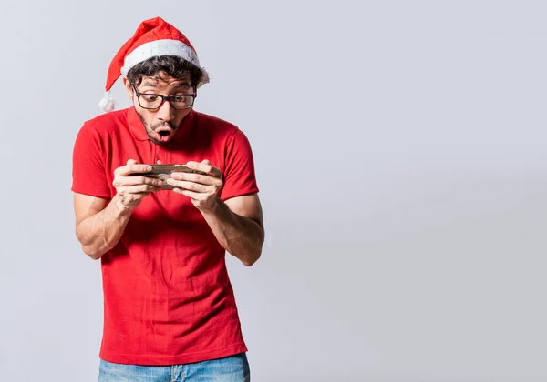 Surprised people watching a christmas promotion on the phone. Amazed man looking at a christmas offer online, Guy looking at a christmas promo on phone. Online christmas special offers concept