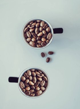 Kahve çekirdekleri fincana düşüyor, kahve çekirdekleri beyaz arka planda, kahve çekirdekleri konsepti.