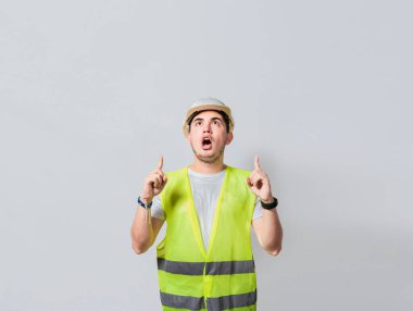 Bir reklama işaret eden inanılmaz bir mühendis. Şaşırmış bir mühendisin boş alanı göstermesi, şaşırmış bir mühendisin işaret etmesi, şaşırmış genç bir mimarın işaret etmesi...