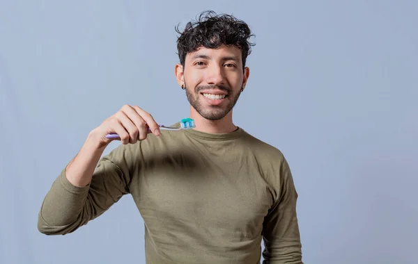 Close up of man holding a dental brush isolated, Handsome man holding dental brush. Tooth brushing and care concept. Smiling guy holding dental brush isolated. Oral and dental smile concept