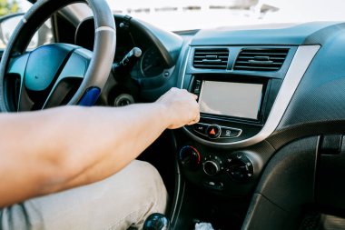 Distracted driver concept tuning the radio. Hand of driver changing radio station, Driver man changing the radio station, Close up of driver tuning into the radio station