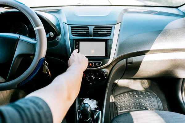 Close up of driver tuning into the radio station. Distracted driver concept tuning the radio. Hand of driver changing radio station, Driver man changing the radio station