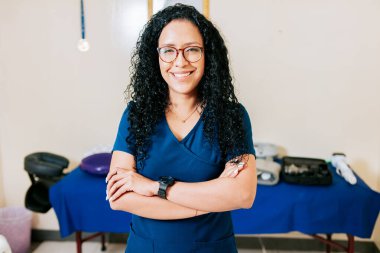 Crossed arms african american physical therapist woman. Smiling woman chiropractor in uniform with arms crossed, Portrait of smiling woman physiotherapist