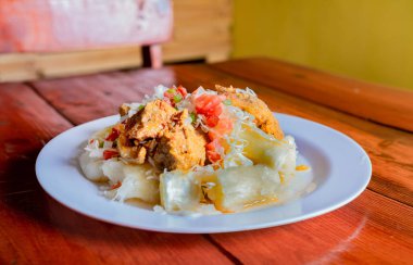 Yuca ile geleneksel Chancho yemeği. Yukka soslu Nikaragua domuzu ahşap masada servis edilir.