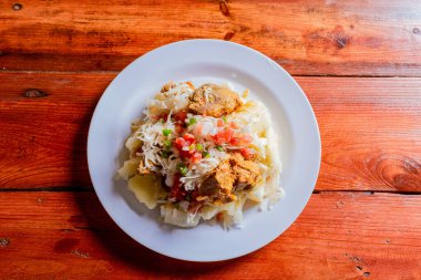 Yuca ile geleneksel Chancho yemeğinin en üst görüntüsü. Yukka soslu Nikaragua domuzu ahşap masada servis edilir.