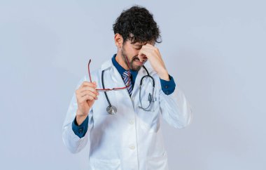 Göz iltihabı olan çok çalışan bir doktor. Doktor yanan gözlüklü gözlük tutuyor.