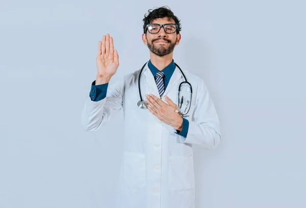 誓いを立てて隔離された約束をするハンサムな医者 医者は手を上げて誓う — ストック写真