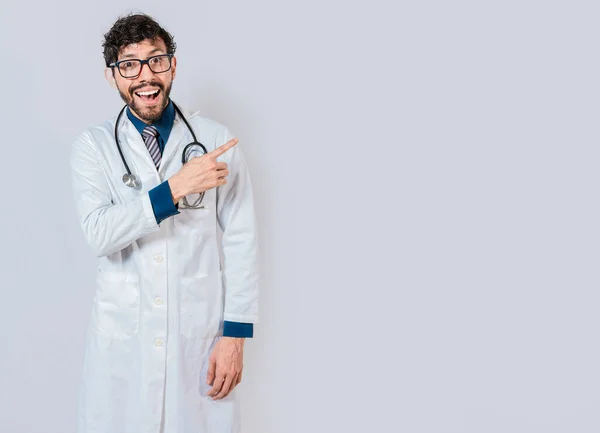 若い医者は指で昇進を指している 広告スペースを指す幸せな医者隔離された 幸せな医師指す右とともに指 — ストック写真