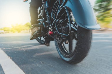 Motosiklet süren bir motosikletlinin alçak açılı görüntüsü. Motosikletli ayaklarının yakınına. Motosikletli bir motorcunun düşük açılı görüntüsü