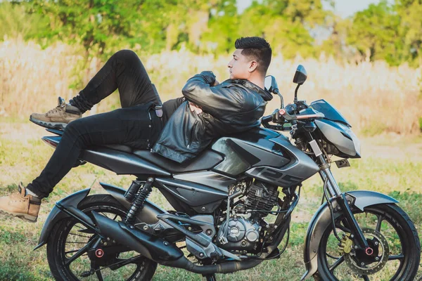 Egy Motoros Férfi Fekszik Motorján Szabadban Motoros Dzsekiben Fekszik Motorkerékpárján — Stock Fotó