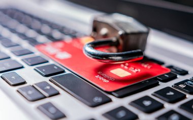 Laptop klavyesindeki kredi kartının üzerindeki asma kilit. Klavyede kredi kartıyla asma kilidi aç. Kredi kartlarında bilgi hırsızlığı kavramı