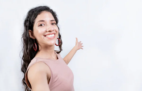 ハッピーガールは 製品を提示することを指摘 隔離された若い女性を歓迎する ラテン語の女の子指すAプロモーションとともに彼女の手のひら — ストック写真