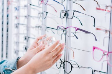 Optik mağazada gözlük seçen bir kadın müşteri. Mağazada gözlük seçen bir kız, mağazada gözlük seçen bir kadın.