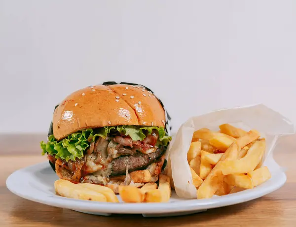 コピースペース付きの木製テーブルにフレンチフライが付いた美味しいハンバーガーのクローズアップ 木のテーブルにフライドポテトチーズバーガー — ストック写真