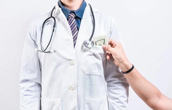 医療賄賂コンセプト 医者を賄う人の手 医師のポケットにお金を入れる手 — ストック写真