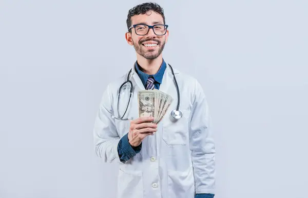 孤立したお金を持っている幸せな若い医師 白い背景でお金を示すハンサムな医師 — ストック写真