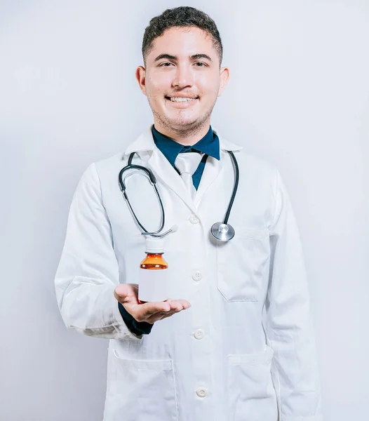 Uśmiechnięty Młody Doktor Pokazujący Butelkę Syropu Lekarz Pokazuje Butelkę Syropu — Zdjęcie stockowe
