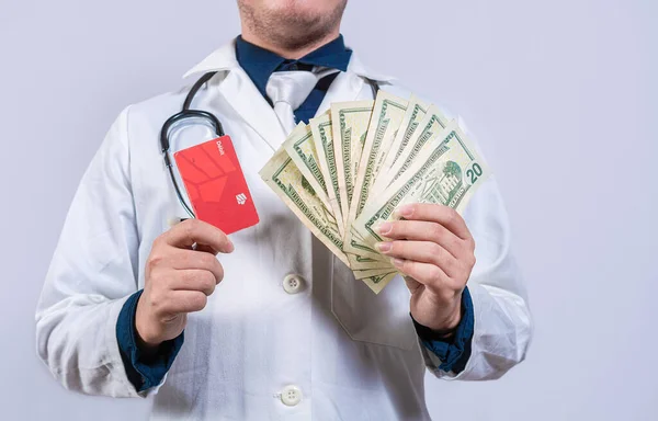 クレジットカードとお金を持っている医師の手は孤立しました 認識できない医師がお金とクレジットカードを隔離 — ストック写真