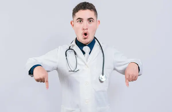 Zaskoczony Młody Doktor Wskazujący Dół Niesamowity Lekarz Wskazujący Promo Dół — Zdjęcie stockowe