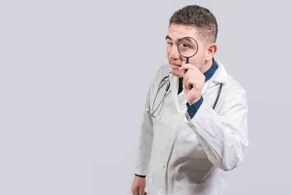Lekarz Trzymający Szkło Powiększające Patrzący Kamerę Odosobnionym Tle Lekarz Szkłem — Zdjęcie stockowe