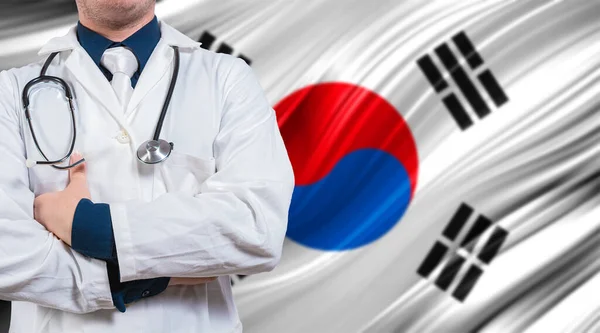 Doctor with stethoscope on South Korean flag. Doctor with crossed arms on South Korean flag. Medical health and care on South Korean flag