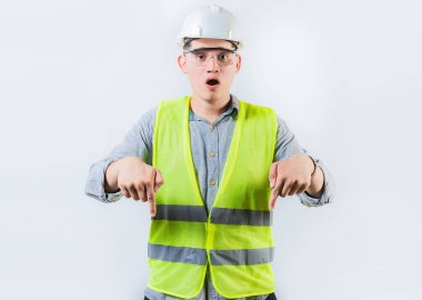 Reklam alanını işaret eden şaşırmış mühendis izole edilmiş. Afallamış erkek mühendis bir reklam alanını işaret ediyor.