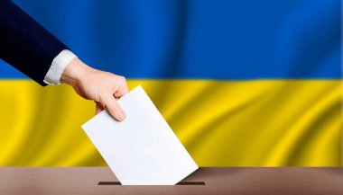 Arka planda Ukrayna bayrağı olan oy sandığında el ele tutuşma. İnsanlar oy sandığına Ukrayna bayrağı arkaplanındaki kağıtları koyuyorlar. Ukrayna seçim seçimleri, kavram