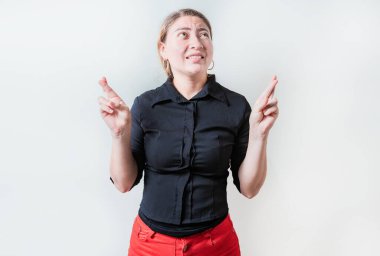 Endişeli genç bir kadın umut verici bir jestle izole edilmiş bir dilek tutuyor. Güzel kız dilek tutuyor.