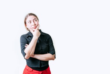 Düşünceli, eli çenesinde meditasyon yapan genç bir kadın izole edilmiş. Güzel bir kız, elleri çenesinde yukarı bakarak düşünür.