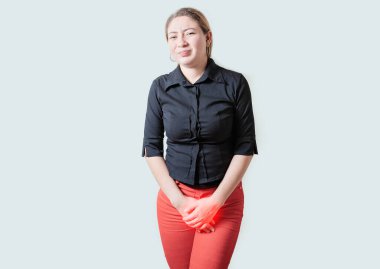 İdrar sorunları olan genç bir kadın izole edilmiş. Elleri apış arasında idrar sorunları olan bir kız.