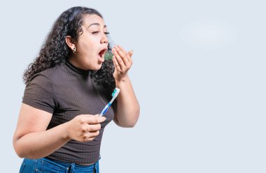 Young woman holding brush with bad breath isolated. Person with brush and bad breath isolated, Person with halitosis clipart