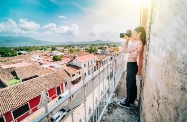 Granada sokaklarını La Merced bakış açısından fotoğraflayan bir turist. Turist kız Granada 'daki koloni evlerinin çatısının fotoğrafını çekiyor.