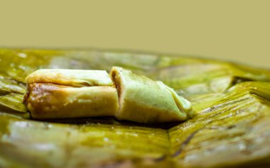 Stuffed tamale served in banana leaves. Close up of a traditional tamale on a banana leaf. Nicaraguan pisque tamale on banana leaf. Tamalpisque traditional Central American food clipart