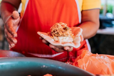 Satıcı kadın geleneksel çiğ pupusa gösteriyor. Geleneksel pupusaların detaylandırılması, geleneksel pupusalar için hamur özetlenmesi