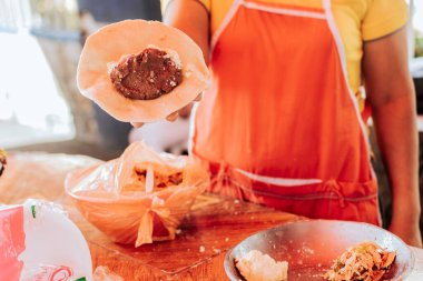 Hands of a vendor showing the process of elaboration of the traditional pupusa. Elaboration of traditional pupusas, Preparation of the dough for traditional Nicaraguan pupusas