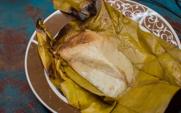 stock image Stuffed tamale served on wooden table, stuffed tamale on banana leaf served on wooden table, typical nicaragua food