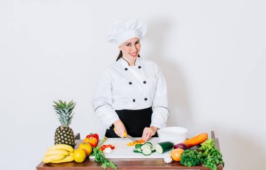 Portrait of female chef cutting vegetables, Female chef preparing salad, a female chef cutting fresh vegetables, Concept of a female chef preparing fresh vegetables