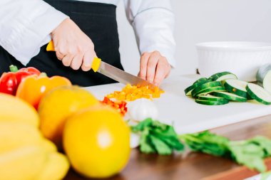 Close up of a female chef cutting vegetables, Hands of female chef cutting vegetables, chef hands preparing and cutting vegetables