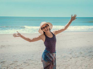 woman in hat happy on the beach, happy pretty young woman on vacation, vacation concept