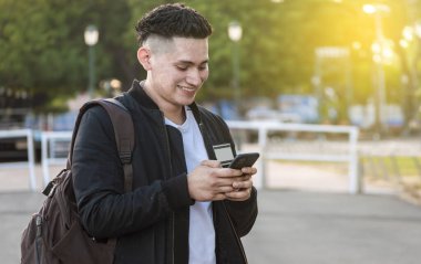 Handsome guy texting with his phone, Handsome young man in face mask texting with his phone, Handsome man texting on his phone