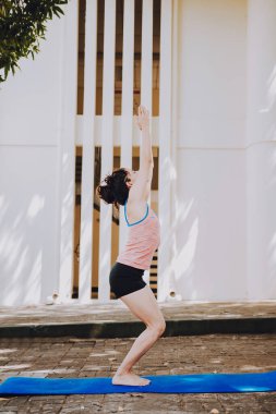 Dışarıda yoga koltuğu pozu veren genç bir kadın. Yoga yapan bir kız UTKATASANA ya da sandalye pozu veriyor. Ashtanga Vinyasa yoga konsepti