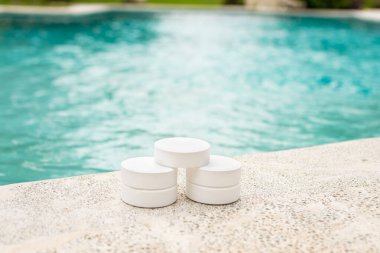 Chlorine tablets on the edge of a swimming pool, Closeup of chlorine tablets for swimming pool cleaning, chlorine tablets for swimming pool disinfection