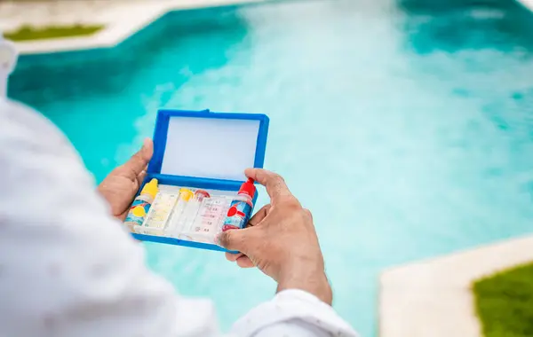 stock image Hand holding Water Test Kit on blurred pool background, Hand holding a pool ph and chlorine tester, Person holding complete water test kit with blurred pool background